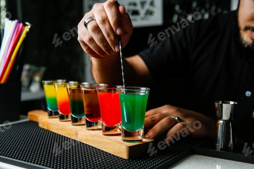 Preview: man stirs the colorful shots green red yellow orange side view