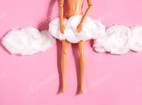Preview: Plastic doll legs with cotton wool clouds covered crotch on pastel pink background.