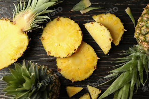 Preview: Ripe pineapples and slices on wooden background, top view