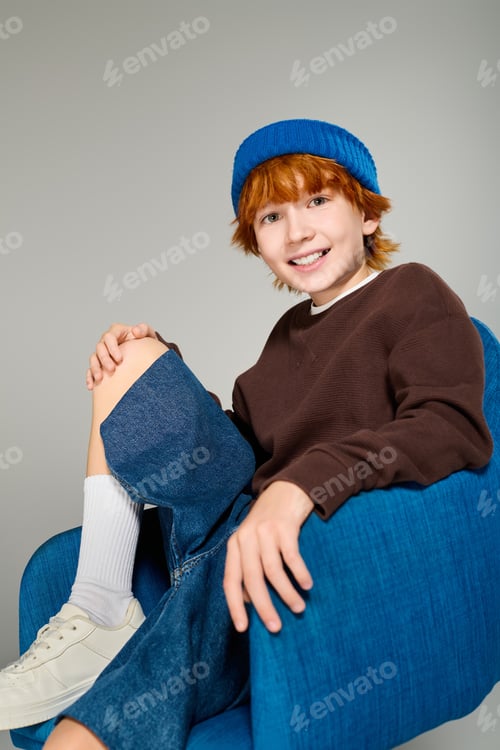 Preview: Stylish redhead boy posing in casual wear in modern studio setting