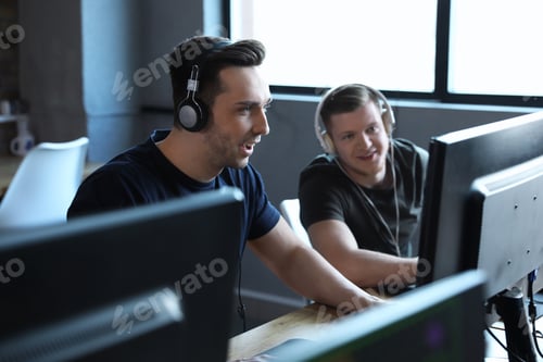 Preview: Men playing video games in internet cafe