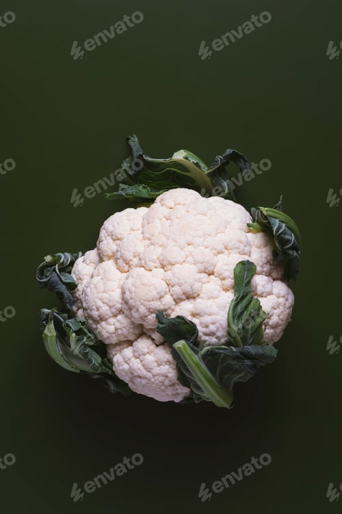 Preview: Fresh cauliflower with leafy greens on dark background, freshness and health benefits of vegetable