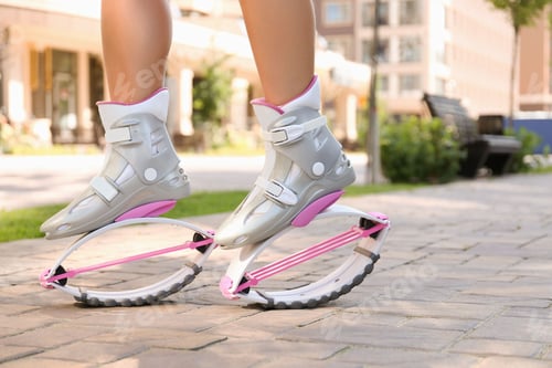 Preview: Girl in kangoo jumping boots on city street, closeup