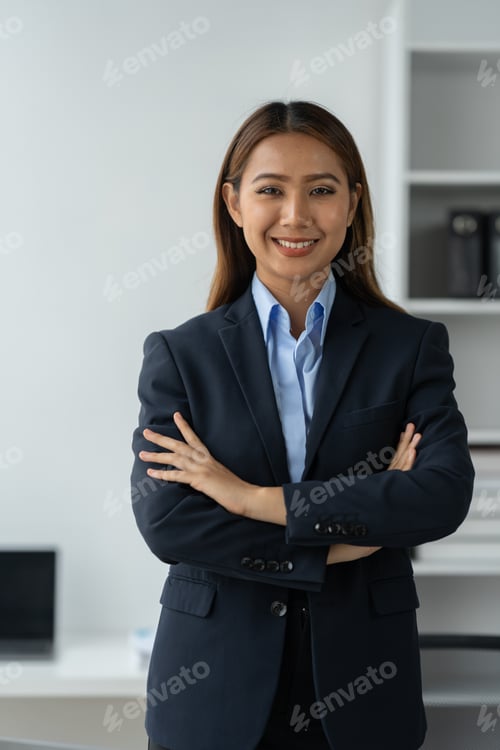 Preview: Cheerful and confident Asian businesswoman standing with arms crossed smiling happily at camera in m