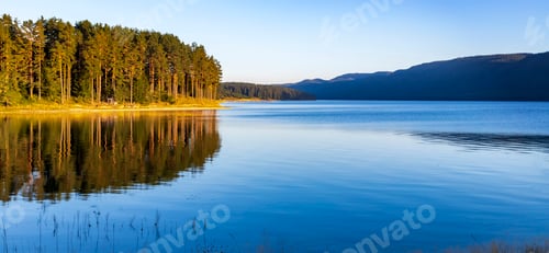 Preview: Idyllic mountain landscape at the lake with calm water, and trees reflection. Panoramic view