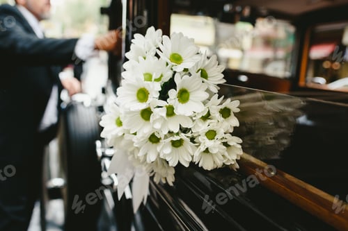 Preview: Bouquet of daisies decorating an antique wedding car.
