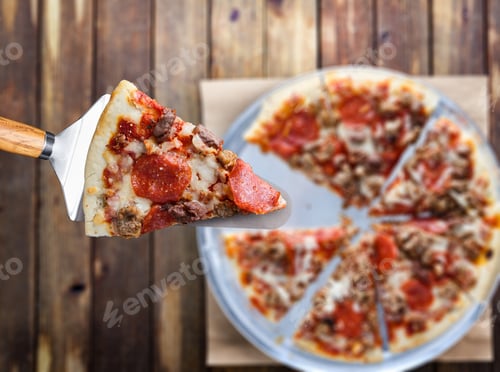 Preview: picking up slice of meaty sausage and pepperoni pizza top down view