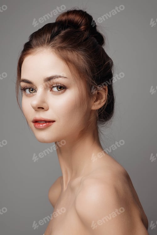 Preview: Portrait of young woman with natural makeup on grey background, studio shot