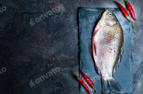 Preview: Fresh fish with spices on a stone board