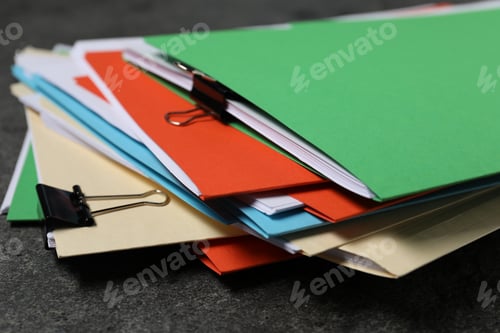 Preview: Many documents in folders with binder clips on grey textured table, closeup