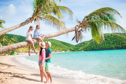 Preview: Kids having fun sitting on the palm tree. Happy family relaxing on tropical Carlisle bay beach with