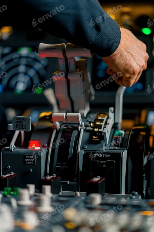 Preview: Close-up of a pilot's hand pressing the throttle in the cockpit of a jet plane reducing engine power