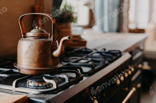 Preview: Old aluminium kettle boiling on gas stove in kitchen against cozy blurred background