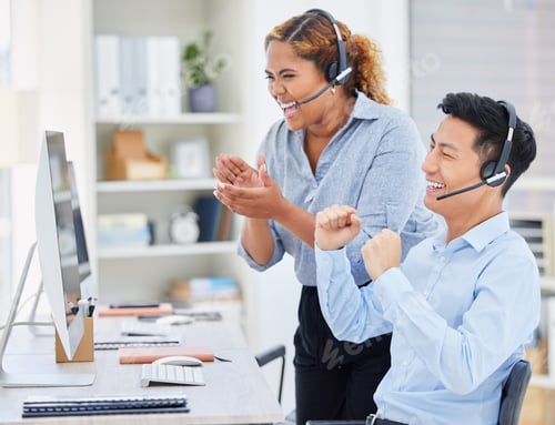Preview: Two happy young diverse call centre telemarketing agents clapping and cheering with joy while worki