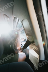Preview: Beautiful Caucasian young hipster female posing during a car trip outside window