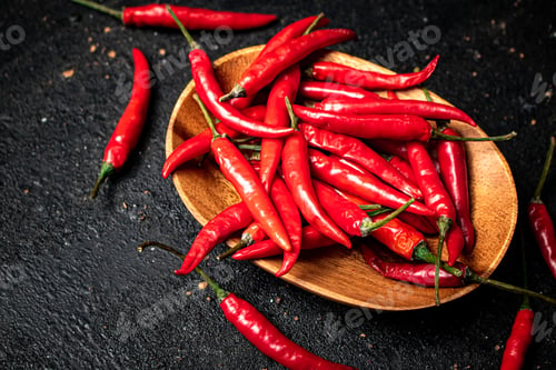 Preview: Chili peppers on a wooden plate.