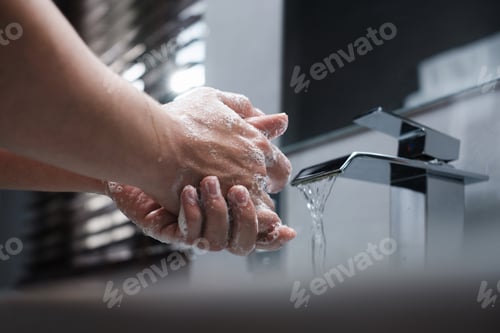Preview: Closeup of Man Washing His Hands With Soap at Bathroom
