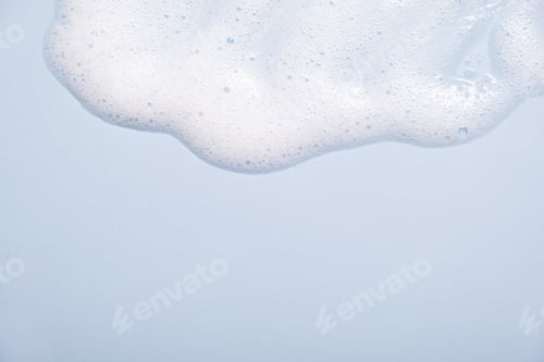 Preview: Face cleansing mousse sample. White cleanser foam bubbles on blue background