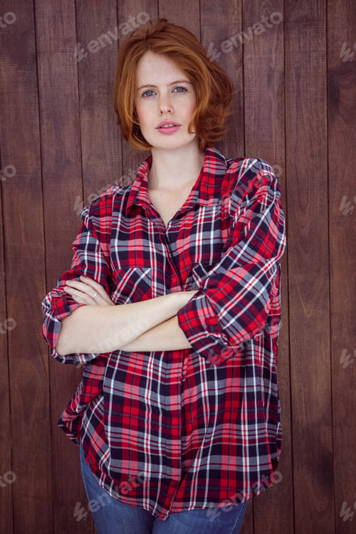 Preview: beautiful hipster woman with her arms crossed against a wooden background