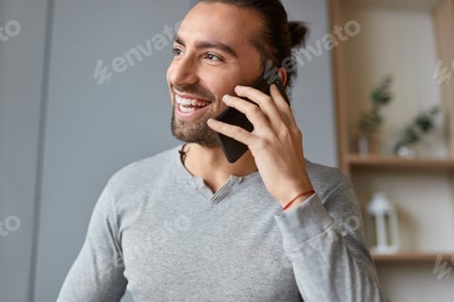 Preview: Cheerful man talking on smartphone
