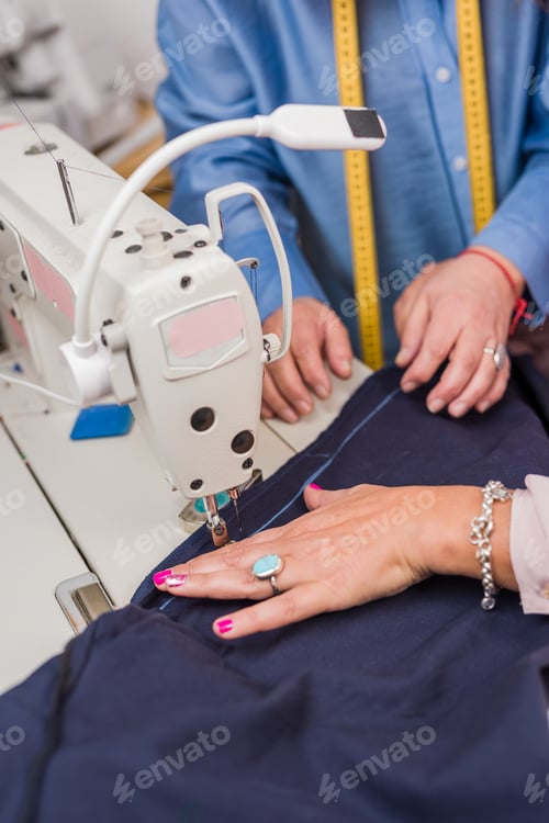 Preview: Atelier process needle detail. Unrecognizable woman hand on a sewing machine doing handmade fabric
