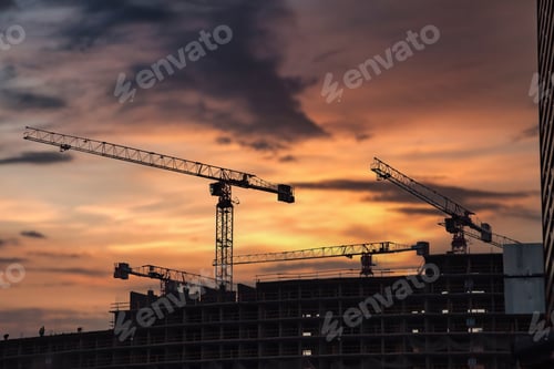 Preview: Construction cranes work on creation site against sky background