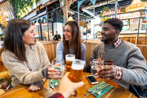 Preview: Happy multi ethnic friends toasting drinks at brewery pub restaurant