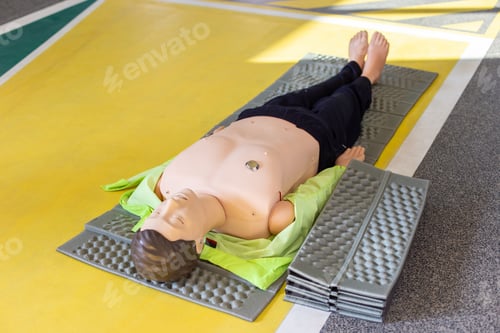 Preview: Full-body CPR training mannequin laid out on a mat for a first aid and resuscitation course