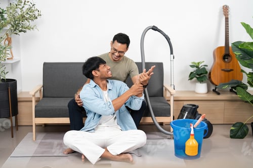 Preview: Joyful cleaning experience. Friends sharing smiles while vacuuming in their cozy home.
