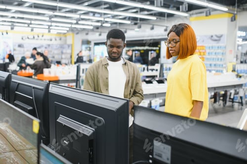 Preview: Beautiful couple buying consumer tech products in modern home appliances store.