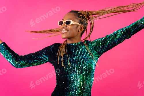 Preview: African young woman with party braids on a pink background, having fun dancing moving her hair