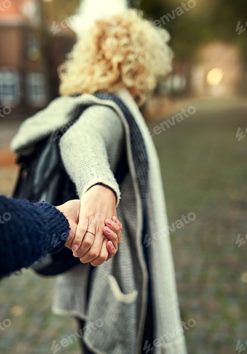 Preview: Come on, love. Rearview shot of a young woman leading her husband through a foreign city.