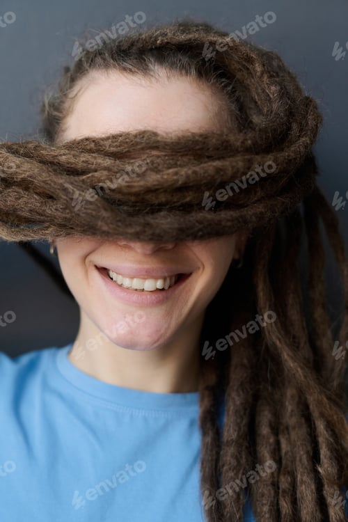 Preview: Smiling Woman with Long Dreadlocks Style Hair Covering Eyes