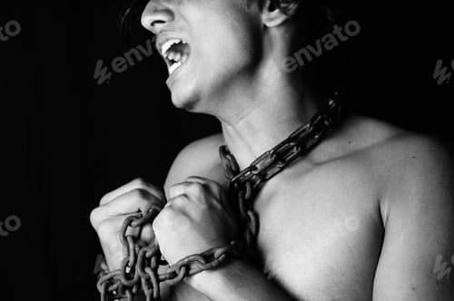 Preview: Grayscale shot of a chained up screaming guy