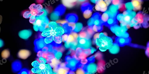 Preview: Multicolored lights bokeh from decorative luminous flowers garlands at holiday, multicolored lights