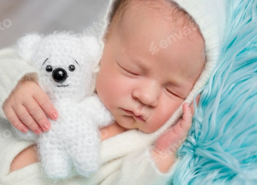 Preview: lovely sleeping newborn boy with little toy, close up