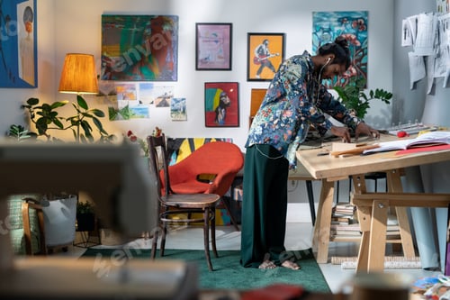 Preview: Creative guy in smart casualwear bending over wooden table during work