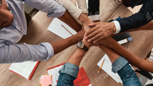 Preview: Strong team. Top view of business people holding hands together while sitting in the office