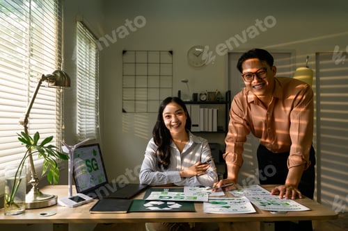 Preview: Asian businesspeople working on sustainable development goals in modern office