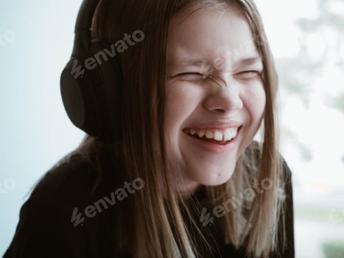 Preview: Teen with Headphones Laughing Indoors in Natural Light