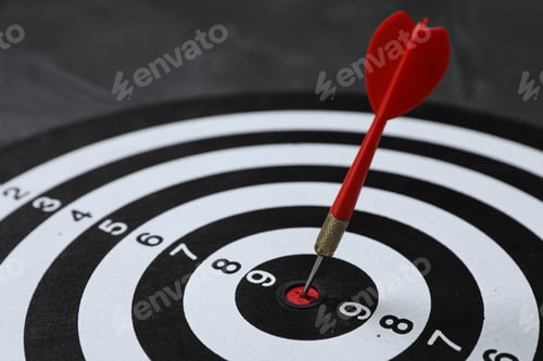 Preview: Targeting. Dart board with arrow on gray background, closeup