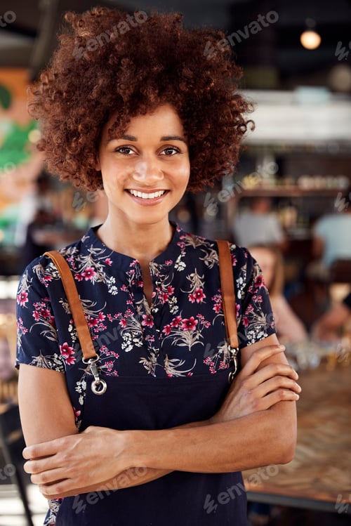 Preview: Portrait Of Waitress Serving In Busy Bar Restaurant