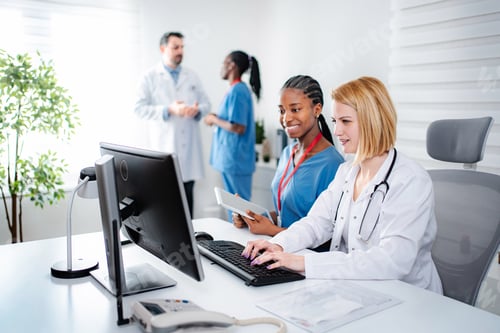 Preview: Medical staff collaborating on computer in clinic office
