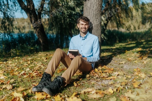 Preview: Happy Moment in Nature Man Reading and Smiling in the Fall Sunlight