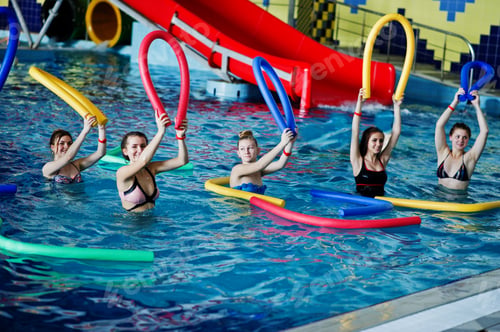 Preview: Fitness group of girls doing aerobical excercises in swimming pool