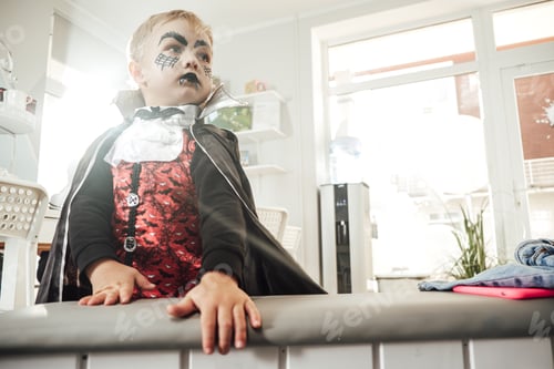 Preview: Little schoolboy dressed like vampire posing in classroom