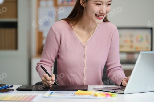 Preview: Female coder or developer working using a computer display and smartphone