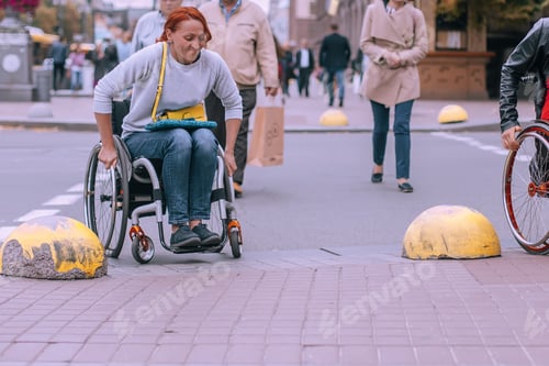 Preview: girls in wheelchairs drive around the restrictive buoys at the pedestrian crossing