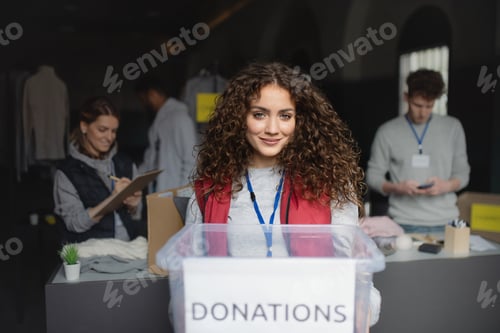 Preview: Woman volunteer working in community charity donation center, looking at camera