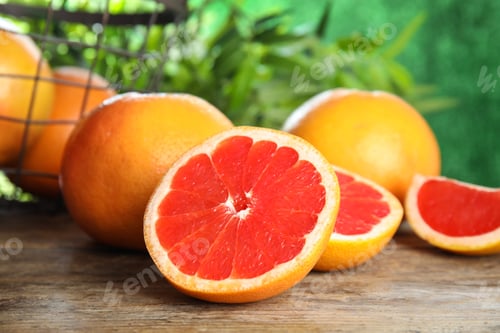 Preview: Fresh tasty grapefruits on table against blurred background